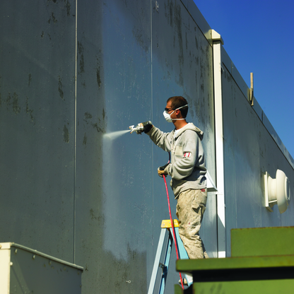 Application de peinture au pistolet sur mur extérieur