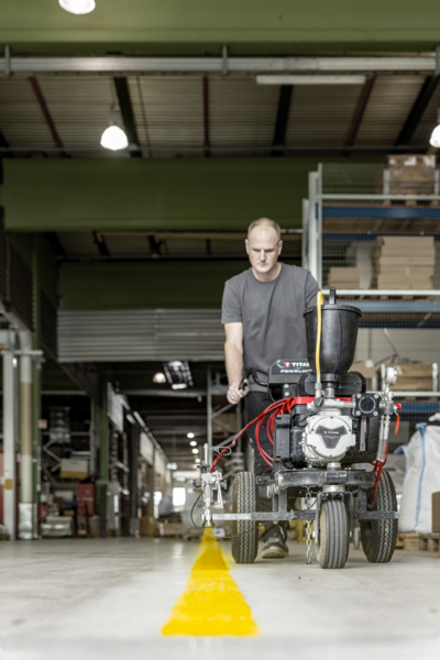 Traceur Titan PowrLiner 3500 traçant une ligne en entrepôt